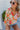 Front view of model wearing the Hopeless Romantic Floral Top, which features a silky material, a multi-colored floral print, a notched neckline with a ruffle detail, long sleeves, and a flowy fit