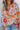 Close-up front view of model wearing the Hopeless Romantic Floral Top, which features a silky material, a multi-colored floral print, a notched neckline with a ruffle detail, long sleeves, and a flowy fit