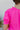 Close-up back view of model wearing the Irreplaceable Top In Pink, which features a hot pink material, a round neckline with a ruffle detail, a cut-out at the chest with adjustable ties, a short smocked sleeve, and a flowy fit
