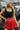 Front view of model wearing the Game On Shorts, which feature a red shimmer material, a smocked waist, a high-rise fit, a ruffle top hem, and a flowy fit.