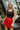 Front view of model wearing the Game On Shorts, which feature a red shimmer material, a smocked waist, a high-rise fit, a ruffle top hem, and a flowy fit.