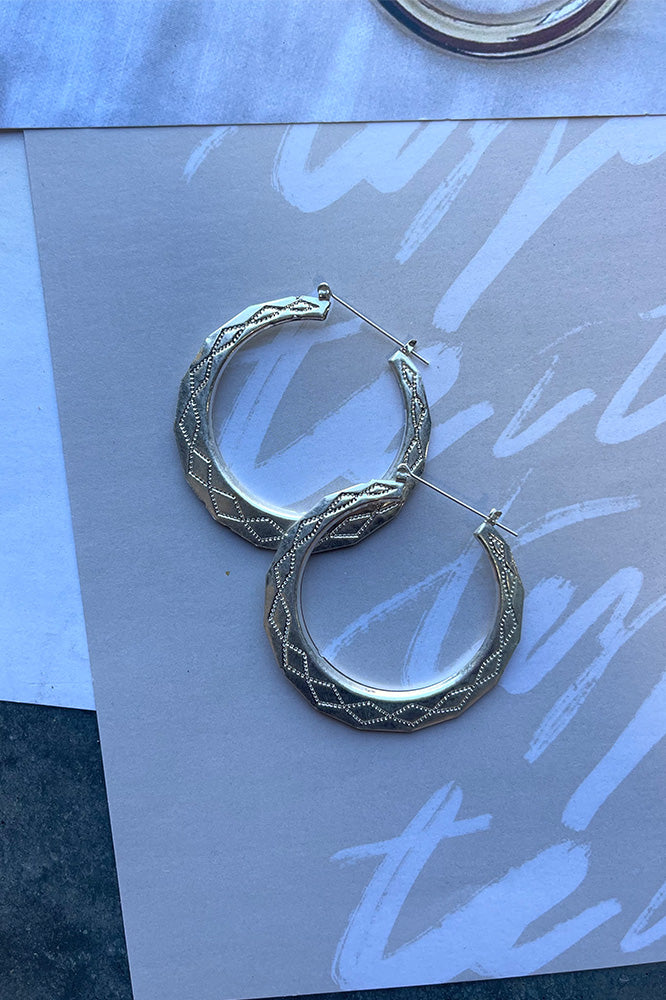 The Essential To You Earring is a silver, hoop style earring, featuring a geometric design through out.