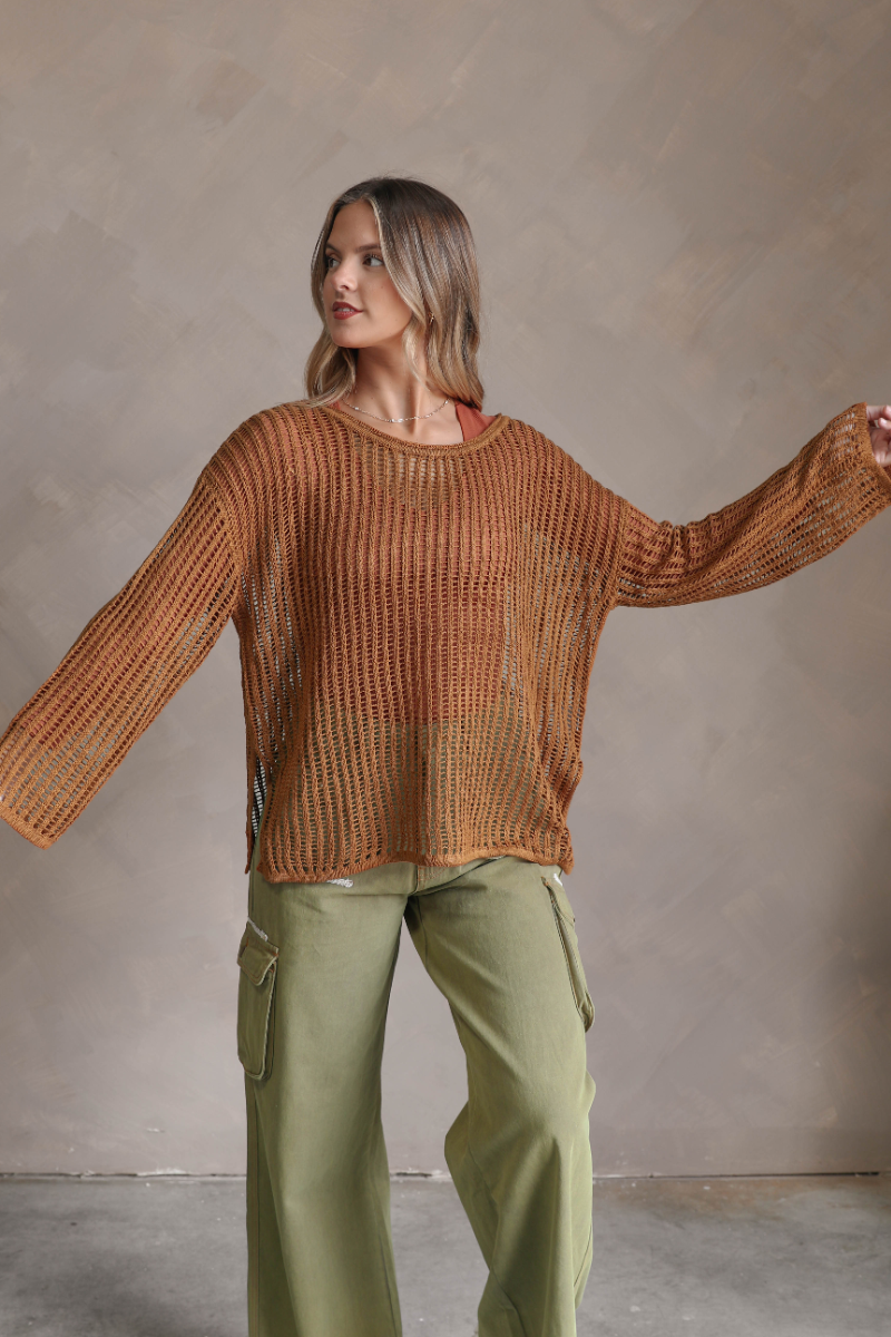 Front view of model wearing the Harlee Camel Open-Knit Sweater which features camel open knit fabric, slits on each side, a round neckline and long wide sleeves.