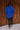 Full body back view of model wearing the Maren Blue Teddy Jacket that has royal blue faux-fur sherpa fabric, tortoise buttons, pockets, a collar, and long sleeves with buttoned cuffs.