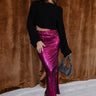 Full body view of model wearing the Lainey Magenta Slit Midi Skirt which features fuchsia and black shimmer pleated fabric, midi length, slit on the side, thigh length fuchsia lining and elastic waistband.