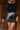 Front view of model wearing the Zara Black & Silver Sequin Mini Skirt which features black sequin and silver sequin fabric, colorblock design, black lining, mini length and back zipper.