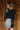 Back view of model wearing the Zara Black & Silver Sequin Mini Skirt which features black sequin and silver sequin fabric, colorblock design, black lining, mini length and back zipper.