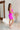 Full body side view of model wearing the Don't Be Shy Dress , which features a purple material, a halter neck with a tie, pleat details on the straps, an open back, and a back zipper closure.