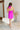 Full body back view of model wearing the Don't Be Shy Dress , which features a purple material, a halter neck with a tie, pleat details on the straps, an open back, and a back zipper closure.