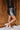 Full body side view of model wearing the Zara Black & Silver Sequin Mini Skirt which features black sequin and silver sequin fabric, colorblock design, black lining, mini length and back zipper.