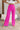 Front view of model wearing the Make A Statement Pants, which feature a pink chiffon material, a high-rise fit, a thick waist band, a wide leg fit, and a back zipper closure