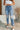 Frontal view of the Out With The Old Jeans that features a medium wash denim with distressing, a front button and zip closure, two front pockets, distressing at the knees and below, a frayed bottom hem, two back pockets, and a straight leg fit.