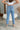 Back view of the Out With The Old Jeans that features a medium wash denim with distressing, a front button and zip closure, two front pockets, distressing at the knees and below, a frayed bottom hem, two back pockets, and a straight leg fit.