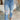 Frontal view of the Out With The Old Jeans that features a medium wash denim with distressing, a front button and zip closure, two front pockets, distressing at the knees and below, a frayed bottom hem, two back pockets, and a straight leg fit.
