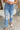 Frontal view of the Out With The Old Jeans that features a medium wash denim with distressing, a front button and zip closure, two front pockets, distressing at the knees and below, a frayed bottom hem, two back pockets, and a straight leg fit.
