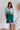 Frontal view of the Sweet Summer Romper that features a multi-colored design, a V neckline, a half cuffed sleeve, a three tiered design, two side pockets, a shorts lining, a V back with a tie detail, a flowy fit, and a mini length.