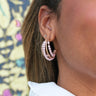 Side view of model wearing the Pretty In Pink Pearl Earring which features open medium gold braided hoops with light pink pearls.