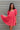 Frontal view of the Bubble Gum Mini Dress that features a pink cotton material, a squared neckline, a half sleeve, a tiered babydoll design, a back button closure, a flowy fit, and a mini length.