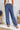 Frontal view of the On Your Mark Pants that features a blue satin material, a high-rise fit, a thick waist band, a clasp and zipper front closure, side pockets, a wide leg fit, and two back pockets.