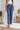 
Frontal view of the On Your Mark Pants that features a blue satin material, a high-rise fit, a thick waist band, a clasp and zipper front closure, side pockets, a wide leg fit, and two back pockets.
