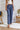 
Frontal view of the On Your Mark Pants that features a blue satin material, a high-rise fit, a thick waist band, a clasp and zipper front closure, side pockets, a wide leg fit, and two back pockets.
