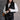 Front view of model wearing the Sienna Black Sherpa Cropped Zip-Up Vest which features black suede and black sherpa fabric, two front pocket slits, front zip up, collared neckline, cropped waist and sleeveless.
