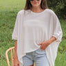 Front view of model wearing the Reset And Refresh Top which features white knit fabric, small slits on each side, a round neckline, and short sleeves.