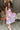 Full body view of model wearing the In My Favor Midi Dress which features a hot pink, light pink, green, blue and lavender color block pattern, tiered ruffle details, a pink skirt lining, a square neckline, adjustable straps, a smocked back, and a monochr