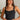 Front view of model wearing the Billie Cropped Denim Tank that has black acid wash fabric, a cropped waist, a square neckline, a sleeveless design, and a monochromatic back zipper with a hook closure.