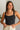 Front view of model wearing the Billie Cropped Denim Tank that has black acid wash fabric, a cropped waist, a square neckline, a sleeveless design, and a monochromatic back zipper with a hook closure.
