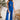 Front view of model wearing the Get On My Level Jumpsuit that has royal blue fabric, a front key hole , a halter neck with button closures, a sleeveless design, an open back, a back zipper with a hook closure, and flare pant legs.