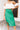 Frontal view of the Flow With Me Midi Skirt that features a green monochromatic houndstooth pattern, an elastic waistband, a side slit, and a midi length.