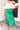 Frontal view of the Flow With Me Midi Skirt that features a green monochromatic houndstooth pattern, an elastic waistband, a side slit, and a midi length.