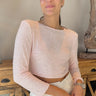 Front view of model wearing the Shine On Sequin Top in Pink, that has pink material with pink sequins, a pink lining, 3/4-length sleeves with shoulder pads, and an exposed back zipper