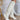 The Stephanie Boot is a tall white boot featuring a faux white leather, a 3" stacked heel, a pointed toe, and pull-on tabs. 