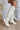 The Stephanie Boot is a tall white boot featuring a faux white leather, a 3" stacked heel, a pointed toe, and pull-on tabs. 