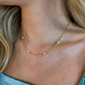 Close view of model wearing the Dinner Date Necklace that features double 15" gold chains with pearl beading.