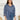 Frontal view of the On Your Mark Top that features a blue silky material, a collared neckline, a button-up front, and a long cuffed sleeve.