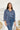 Frontal view of the On Your Mark Top that features a blue silky material, a collared neckline, a button-up front, and a long cuffed sleeve.