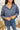 Frontal view of the On Your Mark Top that features a blue silky material, a collared neckline, a button-up front, and a long cuffed sleeve.