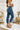 Side view of the Flying Monkey: Ease Mom Jeans that features a dark wash denim, a front button and zip closure, two front pockets, a cuffed bottom hem, two back pockets, and a mom jean fit.