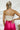 Back view of the My Muse Crop Top that features an ivory PU material, a sleeveless design with a straight neckline, a bow detail at the bust, a smocked back, and a cropped fit.