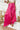 Frontal view of the High Standards Pants that features a pink silk material, a high rise fit, a thick elastic waist band, a pleated design, and a wide leg fit.