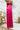 Side view of the High Standards Pants that features a pink silk material, a high rise fit, a thick elastic waist band, a pleated design, and a wide leg fit.