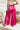 Back view of the High Standards Pants that features a pink silk material, a high rise fit, a thick elastic waist band, a pleated design, and a wide leg fit.