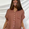 Frontal view of the Golden Days Top that features a brick material, a collared neckline, a short cuffed sleeve, a button-up front, a front pocket, and a flowy fit.