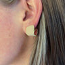 Close up view of model wearing the Keep It Classy Earrings which features scooped stud with gold and nude details.