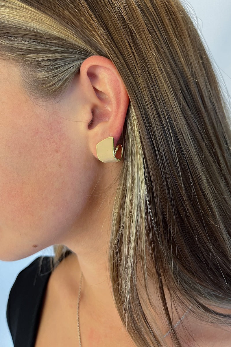 Side view of model wearing the Keep It Classy Earrings which features scooped stud with gold and nude details.