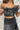 Frontal view of the My Muse Crop Top that features a black PU material, a sleeveless design with a straight neckline, a bow detail at the bust, a smocked back, and a cropped fit.