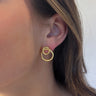 Side view of model wearing the Together Forever Earrings which features one medium circle linked with a smaller gold circle stud.